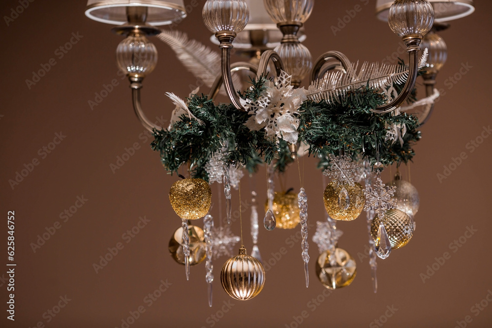 Stylish gold and crystal-clear toys on the Christmas tree. Beige tones. The concept of interior decoration and stylish new year and Christmas 2024.