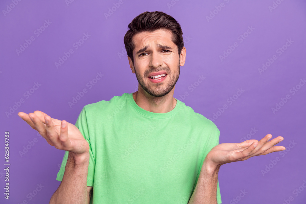 Photo of funny young guy shrug shoulders wearing green t-shirt dissatisfied misunderstanding dude chill isolated on violet background Photo of funny young guy shrug shoulders wearing green t-shirt dissatisfied misunderstanding dude chill isolated on violet background
