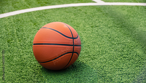 basketball ball on the green artificial turf in outdoors court