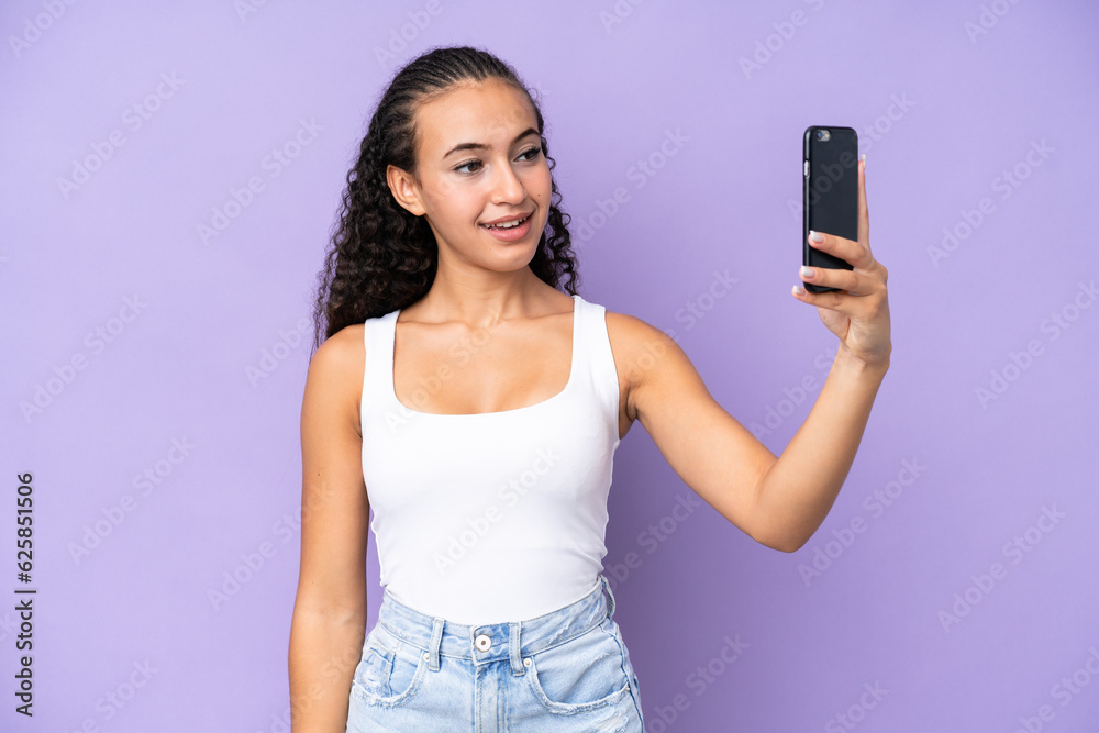 Young woman isolated on purple background making a selfie Young woman isolated on purple background making a selfie