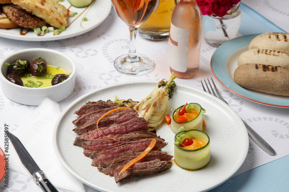 Delicious cuts of medium rare beef tenderloin with with herbed steak sauce served on the restaurant table Delicious cuts of medium rare beef tenderloin with with herbed steak sauce served on the restaurant table