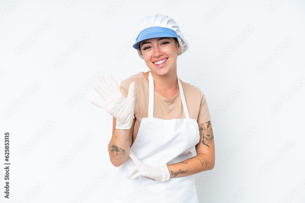 Fishmonger wearing an apron and holding a raw fish isolated on white background counting five with fingers Fishmonger wearing an apron and holding a raw fish isolated on white background counting five with fingers