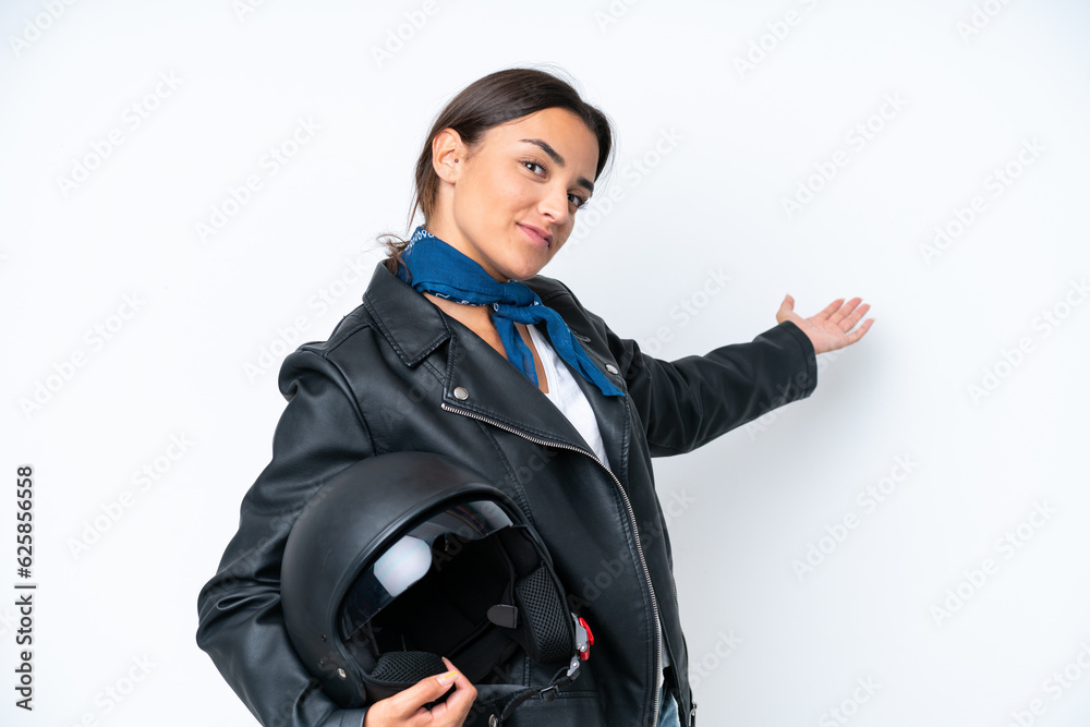 Young caucasian woman with a motorcycle helmet isolated on blue background extending hands to the side for inviting to come Young caucasian woman with a motorcycle helmet isolated on blue background extending hands to the side for inviting to come