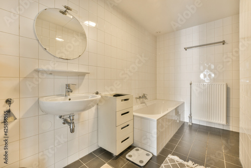a white bathroom with black tile flooring and wall mounted mirror above the sink in the room is very clean