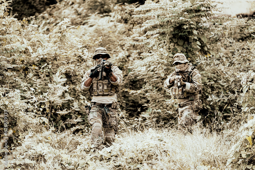 Naklejka premium United States Army ranger during the military operation. Professional marine soldiers training with weapon on a military range.
