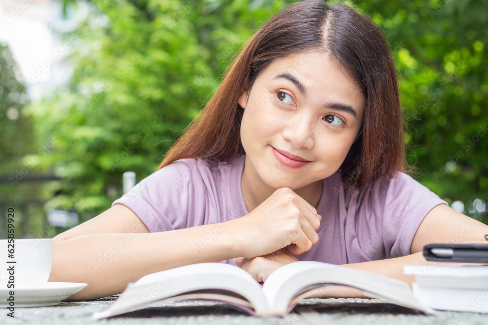 Obraz premium Close-up front view of Asian woman reading a book in the backyard show many emotions
