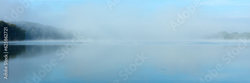 Morning fog on the lake on a summer day