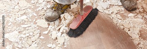фотографія Builder sweeping the floor after renovation