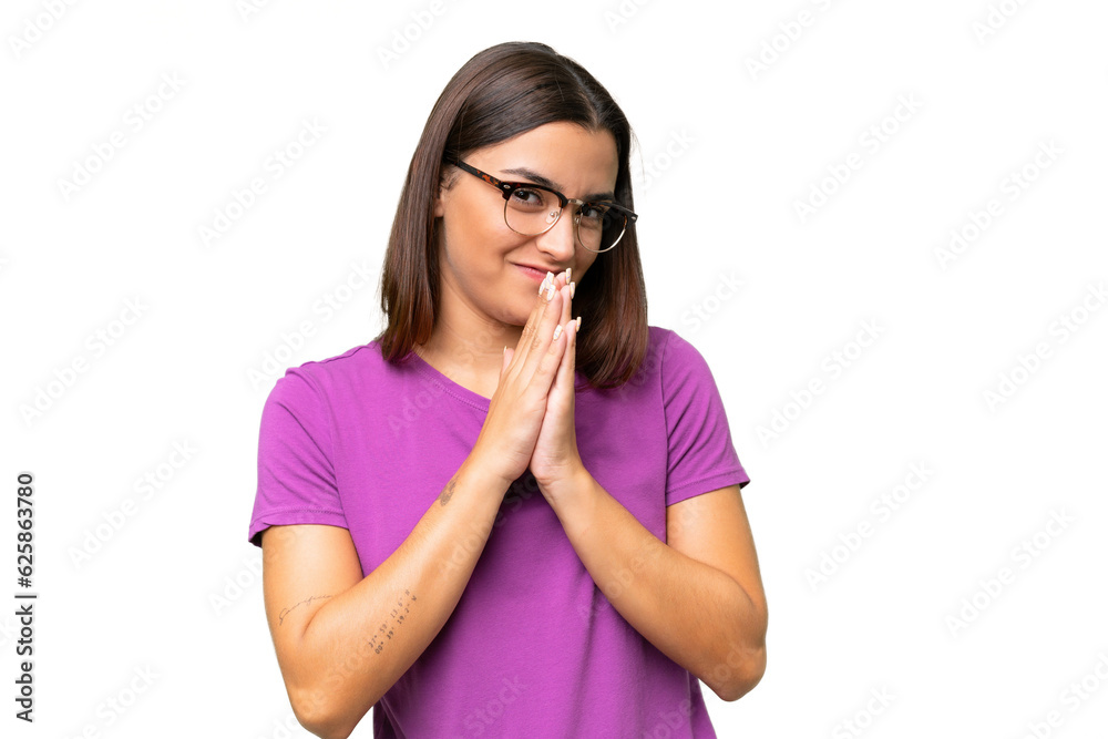 Young caucasian woman isolated on green chroma background keeps palm together. Person asks for something Young caucasian woman isolated on green chroma background keeps palm together. Person asks for something