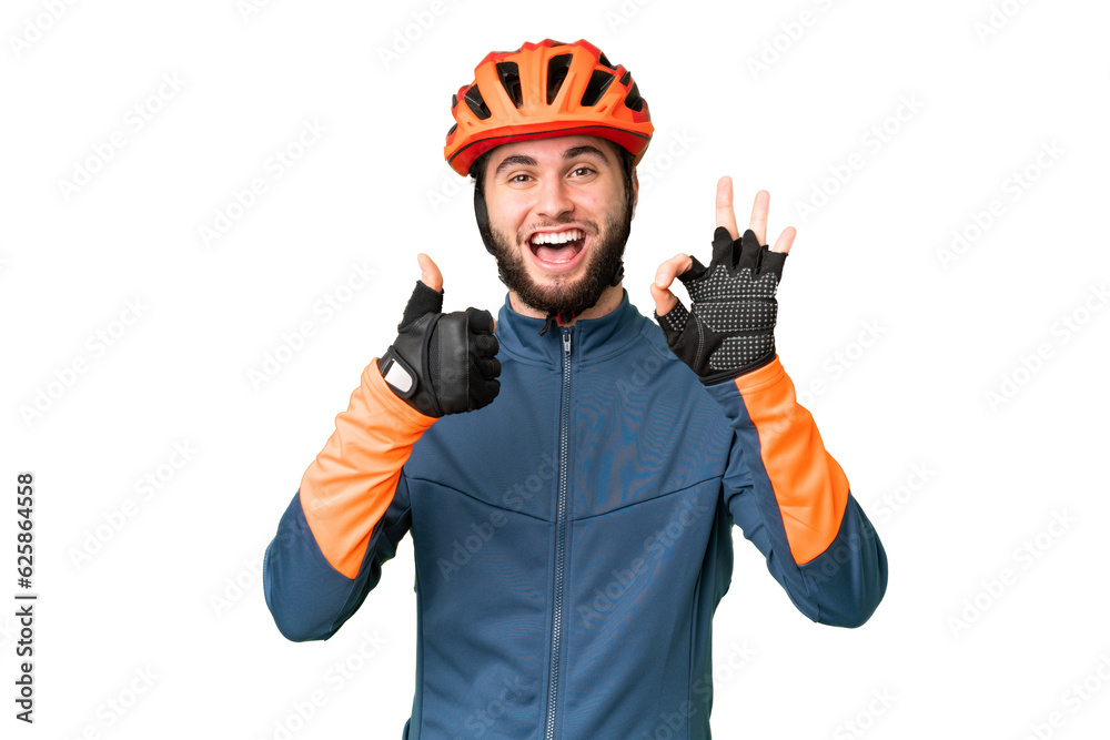 Young cyclist man over isolated chroma key background showing ok sign and thumb up gesture
