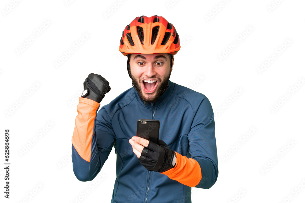 Young cyclist man over isolated chroma key background surprised and sending a message - obrazy, fototapety, plakaty 