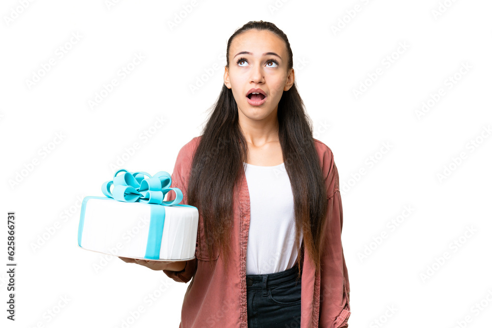 Young Arabian woman holding birthday cake over isolated chroma key background looking up and with surprised expression Young Arabian woman holding birthday cake over isolated chroma key background looking up and with surprised expression