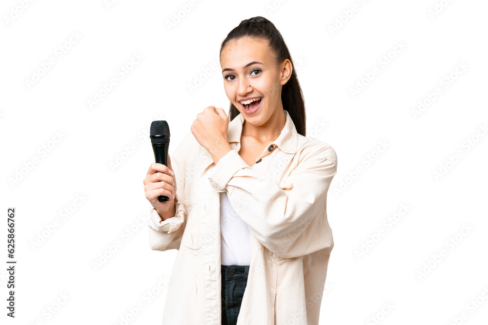 Young singer woman picking up a microphone over isolated chroma key background celebrating a victory Young singer woman picking up a microphone over isolated chroma key background celebrating a victory