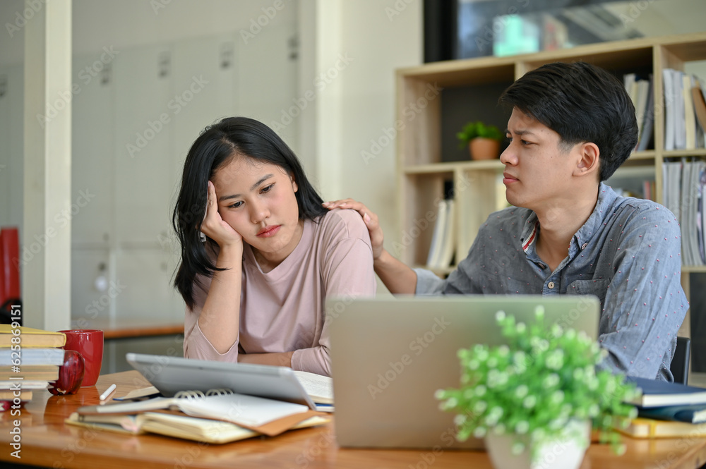 A caring and kind young Asian man is trying to comfort his stressed-out girl friend A caring and kind young Asian man is trying to comfort his stressed-out girl friend