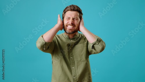 Male covers ears and shakes head hearing unpleasant sound