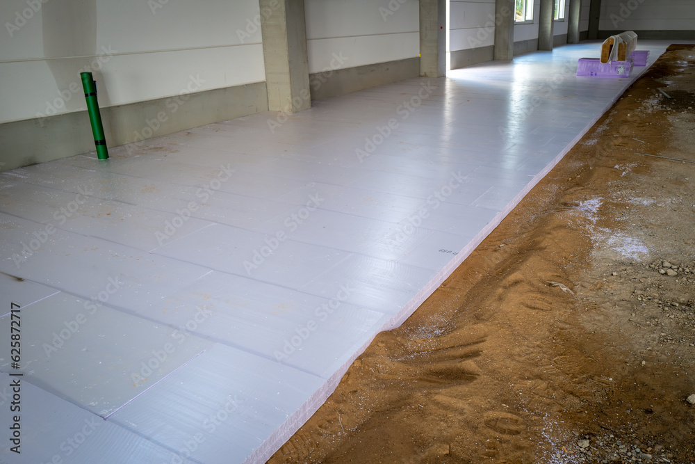 styrofoam panels are laid on the floor of a newly built factory building for insulation purposes
