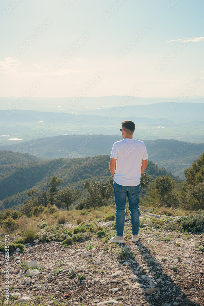 Fototapeta premium Man on the top of a mountain looking towards the horizon