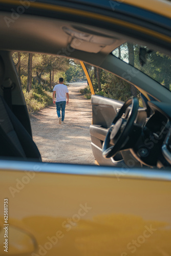 Latino man getting out of a vehicle on a forest road