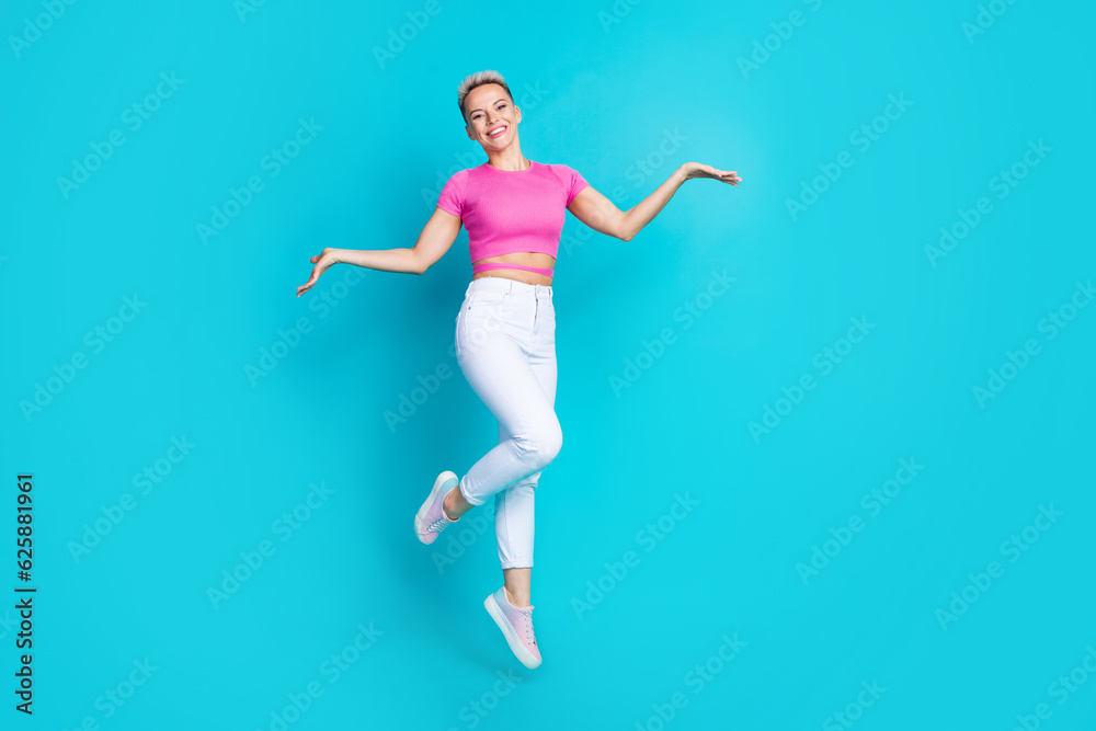 Full size photo of attractive young woman walking elegantly jump wear trendy pink clothes isolated on aquamarine color background