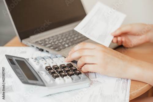 girl pays utility bills online. Women's hands count on a calculator, an accountant works with documents