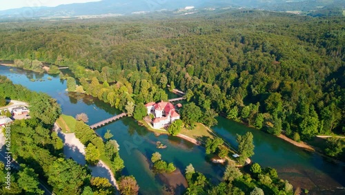 Picturesque 4K drone footage of Castle Otočec in beautiful sunny light. Video shows this historic gem embraced by the Krka River. Captivating Slovenia's beauty from aerial perspective. photo