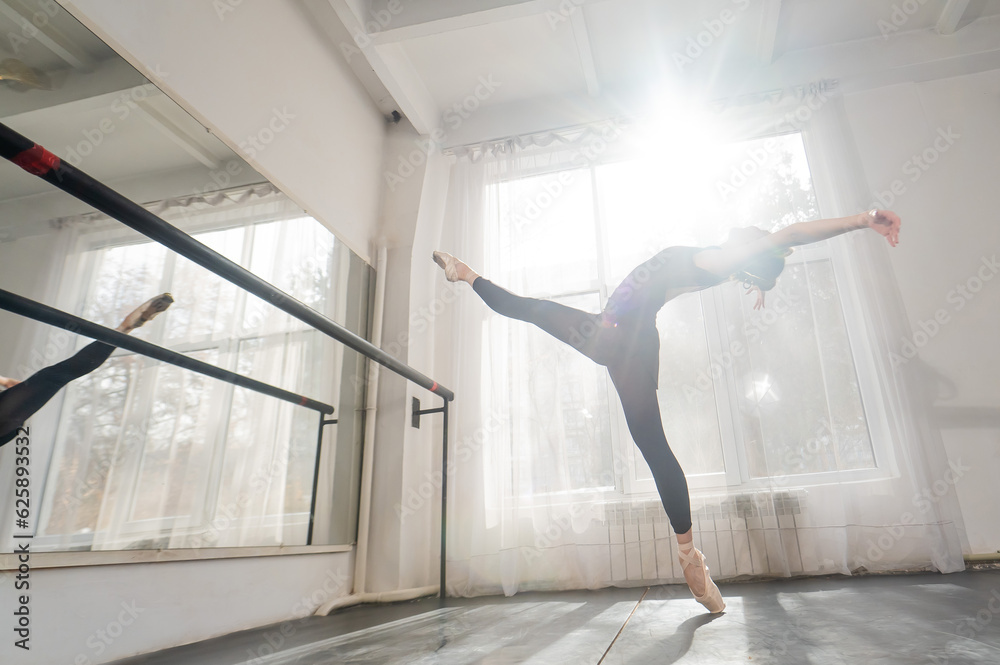 A beautiful Asian woman is dancing at the barre. Ballet dancer.