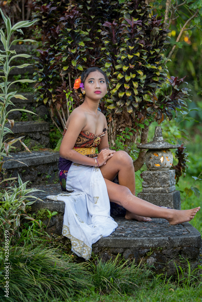 Beautiful Bali women siting in traditional dress in the garden. Indonesia. Beautiful Bali women siting in traditional dress in the garden. Indonesia.