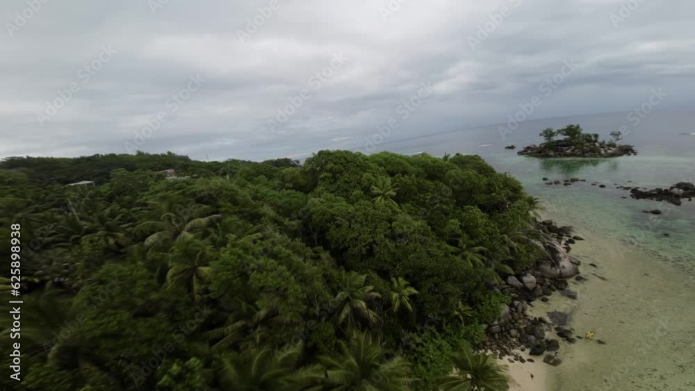 Fpv drone flying on a beautiful beach in Seychelles on an Island Mahe, video of incredible trees, Seychelles rocks, seaside, and surrounding Seychelles landscapes. The drone moving close and fast Fpv drone flying on a beautiful beach in Seychelles on an Island Mahe, video of incredible trees, Seychelles rocks, seaside, and surrounding Seychelles landscapes. The drone moving close and fast