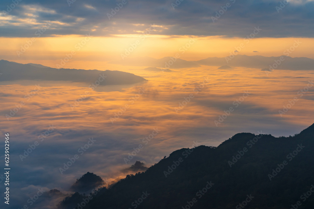 sunrise behind the mountains with sea of cloud and beautiful sky in the northern of Thailand (Phu Chi Dao Chiang Rai Province)