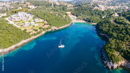 Aerial drone ultra wide panoramic photo of luxury sailboat anchored in tropical exotic island with crystal clear turquoise sea and pine trees