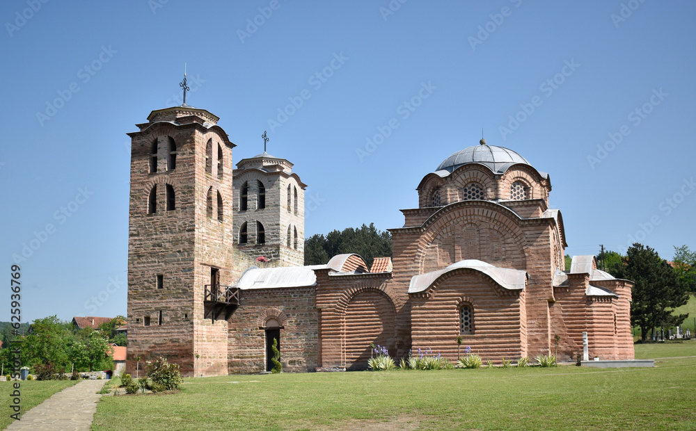 Saint Nicholas Monastery near the town of Kuršumlija in Serbia, Europe.Park and concrete path in the foreground and blue sky in the background.