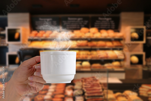 a cup of hot coffee on the background of a bakery