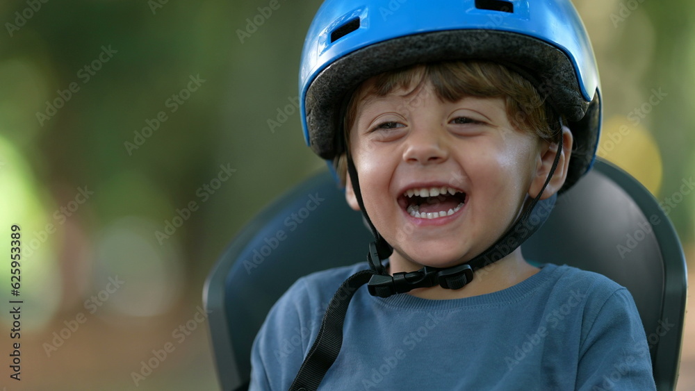 Happy little boy wearing bicycle helmet laughing and smiling Happy little boy wearing bicycle helmet laughing and smiling
