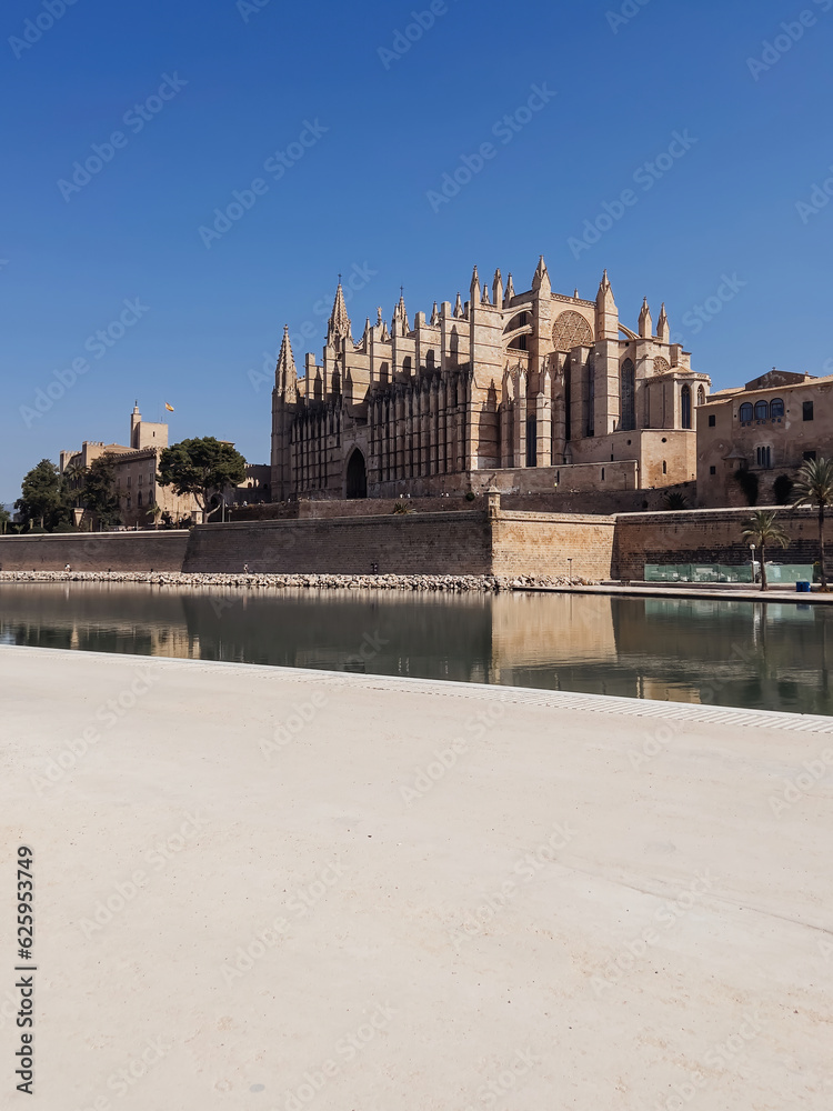 Mallorca Cathedral in Spain, a captivating architectural gem steeped in history. Marvel at its grandeur and admire the clear blue sky backdrop, while taking in the serene waters nearby.
