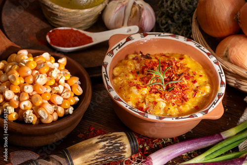 bowl with typical latin american food locro with vegetables and corn on a wooden table