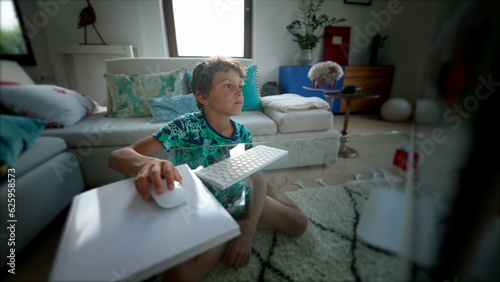 Little boy looking at computer screen in the morning browsing internet