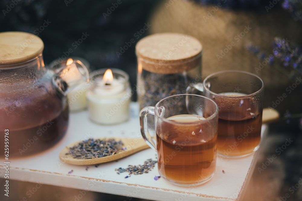 Natural herbal lavender tea on a white wooden tray in a middle of beautiful purple lavender field. Natural herbal lavender tea on a white wooden tray in a middle of beautiful purple lavender field.