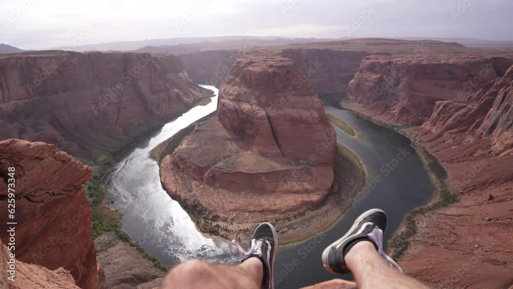 jambes dans le vide face au colorado a Horseshoe Bend en Arizona