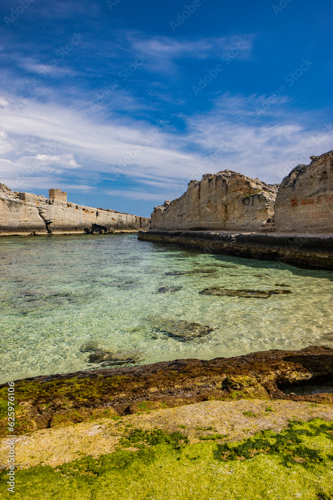 Fototapeta premium The amazing natural pools of Marina Serra, in Puglia, Salento, Tricase. The clear and crystalline turquoise sea, between the rocky cliff. The blue sky, in the summer. The ancient watchtower.