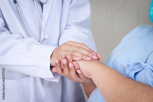 The hands of a doctor hold the hand of a female patient who is being treated in the hospital. concept of medical services in a hospital