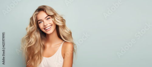 Smiling young woman with blonde long groomed hair isolated on pastel flat background with copy space. Blonde hair care products banner template, hair salon.