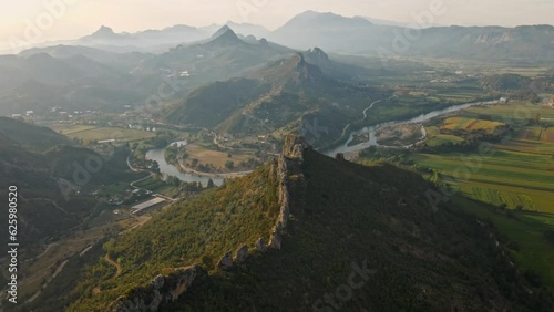 aerial scenic landscape with green fields, meadows, curved mountain river and mountain ridge with high mountains and sunset cloudy sky. Traveling Turkey, Tazi canyon area. cinematic drone filming 4k photo