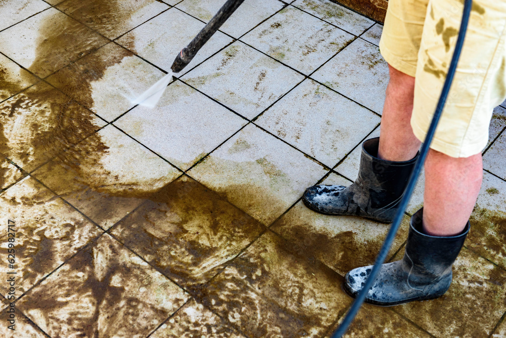 Swimming pool cleaning. A service man is cleaning the pool ground with a high-pressure washer. Swimming pool cleaning. A service man is cleaning the pool ground with a high-pressure washer.
