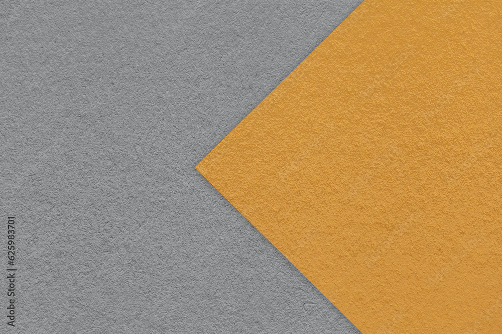 Texture of dark gray paper background, half two colors with orange arrow, macro. Structure of craft grey cardboard. Texture of dark gray paper background, half two colors with orange arrow, macro. Structure of craft grey cardboard.