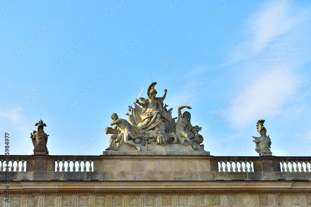 Ancient sculptural group of male warrior with sword, two men and military attributes on the roof of the building. Germany, Berlin, August 2022. Ancient sculptural group of male warrior with sword, two men and military attributes on the roof of the building. Germany, Berlin, August 2022.