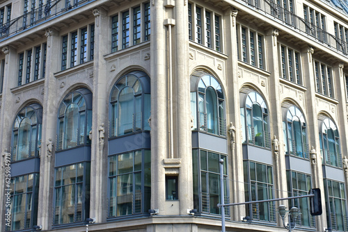 Corner of classic building with grey walls and tall blue glass windows. Urban architecture. Germany, Berlin, August 2022