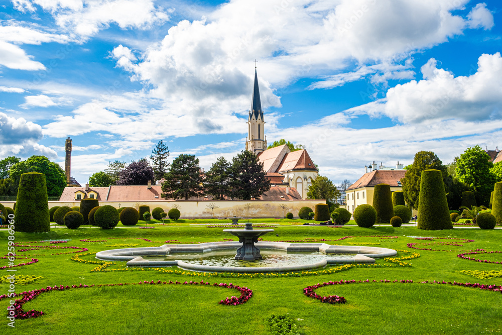A beautiful European park and a view of the fountain and the church in summer.