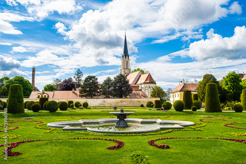 A beautiful European park and a view of the fountain and the church in summer.