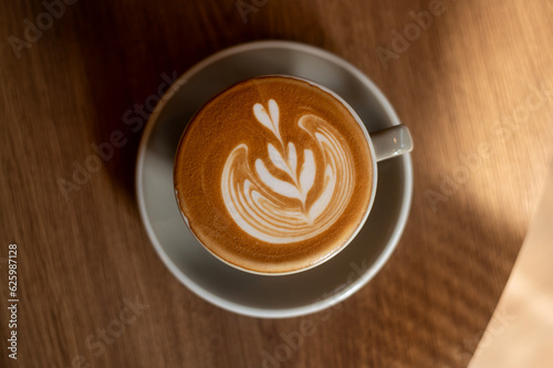 hot cappuccino with latte art on wood background