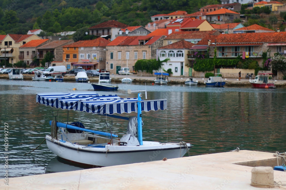Small fishing boat and picturesque skyline in Vela Luka, island Korcula, Croatia.
